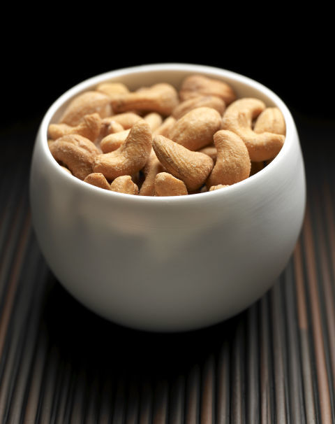 Hạt điều trong một chén trắng, biểu tượng của thực phẩm giảm stress. Bài viết "Bạn nên ăn gì khi bị stress?" khám phá các loại thực phẩm giúp làm giảm căng thẳng và áp lực công việc.