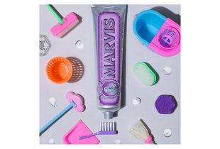 Kem Đánh Răng Marvis Classic Jasmin Mint Hương Hoa Nhài Kết Hợp Bạc Hà 85ml nằm giữa các dụng cụ vệ sinh sáng màu, với tông màu tím đặc trưng, thể hiện sự sang trọng và tinh tế.