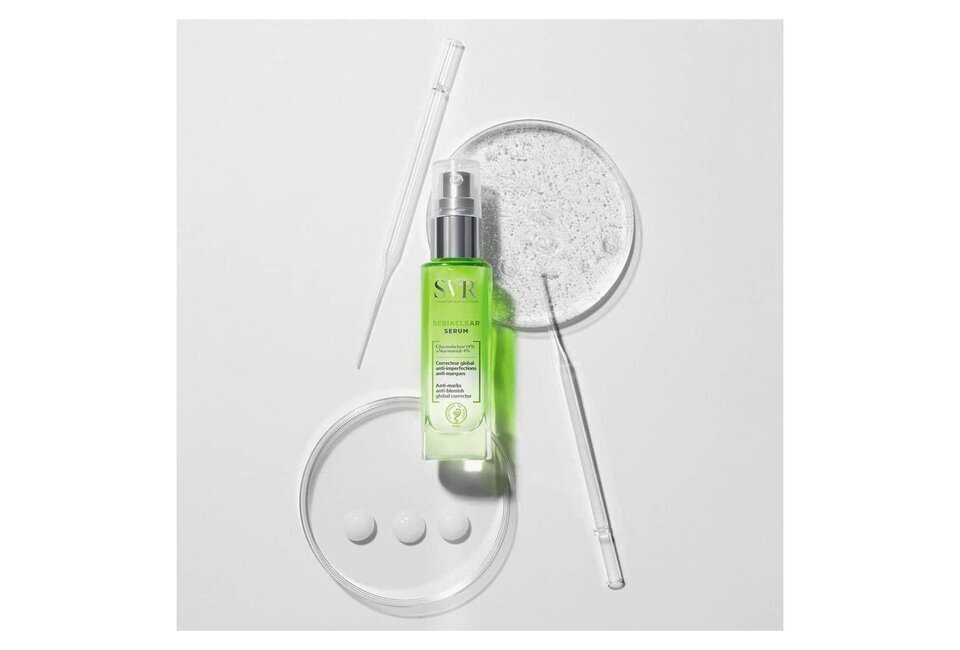 Tinh Chất SVR Sebiaclear Serum Giảm Mụn Mờ Thâm 30ml nằm trên bề mặt phẳng, bên cạnh các dụng cụ thí nghiệm và một đĩa petri chứa gel trong suốt, tạo thành một bối cảnh hiện đại và chuyên nghiệp.