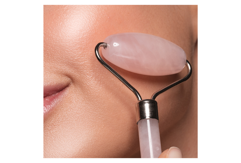 Thanh Lăn Massage Mặt Đá Thạch Anh Hồng Lixibox Rose Quartz Face Roller Massager đang được sử dụng trên làn da, giúp cải thiện độ săn chắc và vẻ rạng rỡ. Hình ảnh nổi bật với chi tiết mặt đá thạch anh hồng và mịn màng.