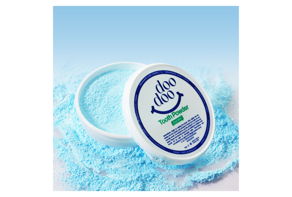 Bột Trắng Răng Doodoo Toothpowder Cool Mint 50g với màu xanh mát, giúp làm trắng và bảo vệ răng miệng hiệu quả. Sản phẩm nằm trong hộp nhựa với nội dung chi tiết trên nắp.