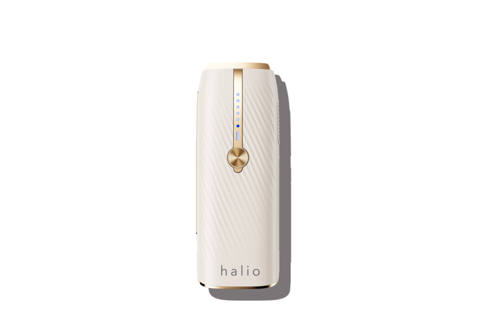 Máy Triệt Lông Lạnh Sapphire Halio InfinityGlow Advanced IPL Sapphire Cooling Hair Removal Device với thiết kế tinh tế màu trắng và vàng, có nút điều khiển và đèn báo hiển thị.