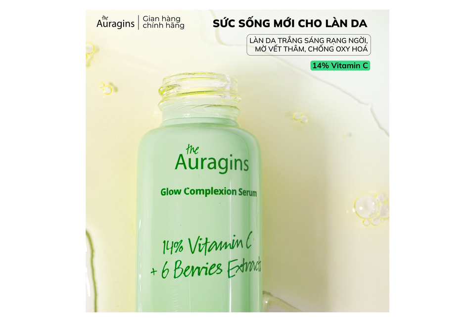 Tinh Chất The Auragins Glow Complexion Serum 14% Vitamin C + 6 Berries Extracts trong chai màu xanh sáng, nền trắng nhẹ với các bọt nước, mang lại vẻ rạng rỡ cho làn da.