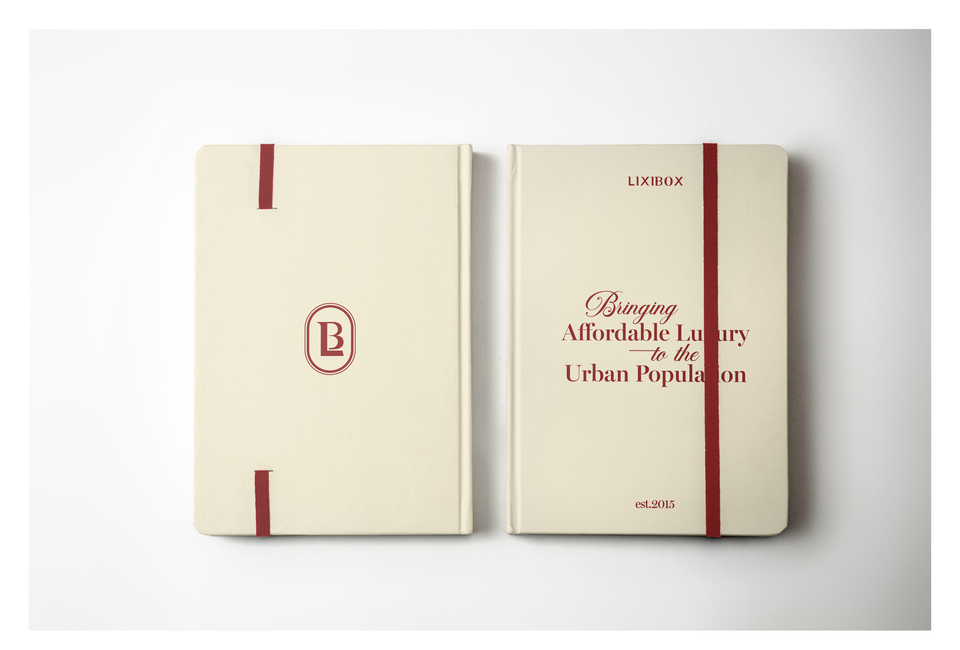 Sổ Tay Lixibox Everyday Notebook với bìa màu kem, có logo Lixibox, một dải băng đỏ và dòng chữ 'Bringing Affordable Luxury to the Urban Population, est. 2015'.